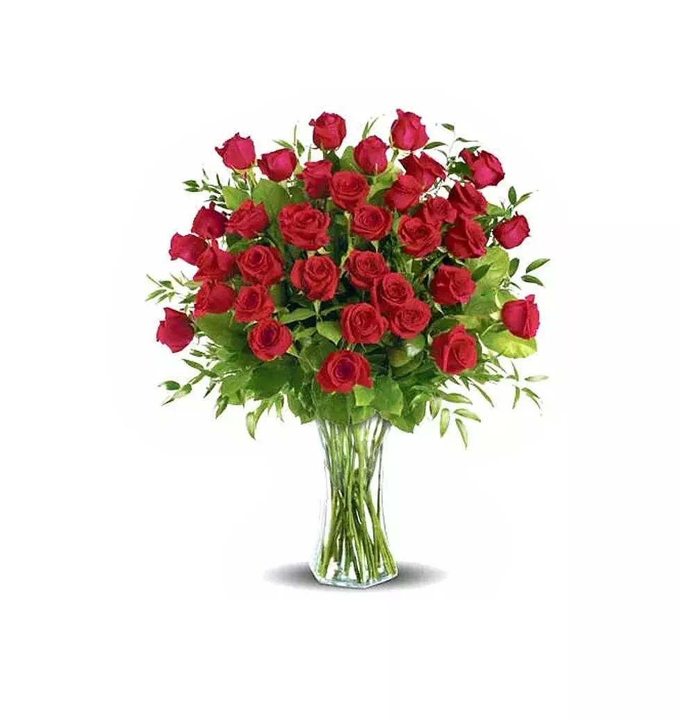 Three dozen long stemmed roses, arranged in a glass vase.